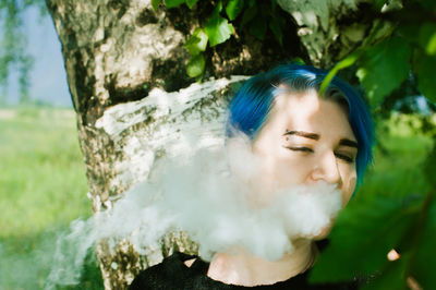 Close-up of young woman smoking electronic cigarette