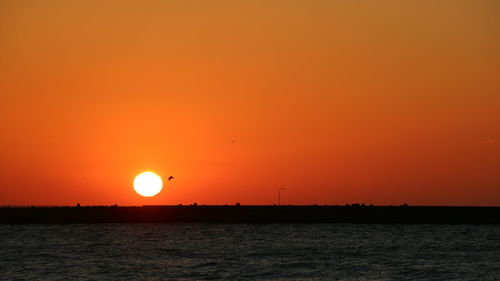 Scenic view of sea against orange sky