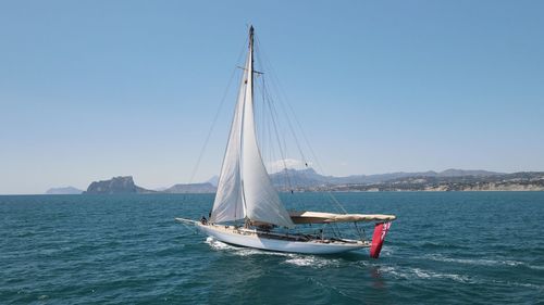 Sailboat sailing on sea against clear sky