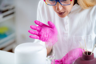 Aroma diffuser in a lab, olfactory science technician smelling the fragrance.