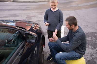 Side view of man holding car