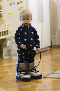 Cute boy standing on hardwood floor