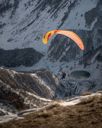 Low angle view of person paragliding against mountain