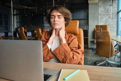 Portrait of young woman using laptop on table