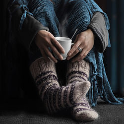 Low section of woman holding coffee cup