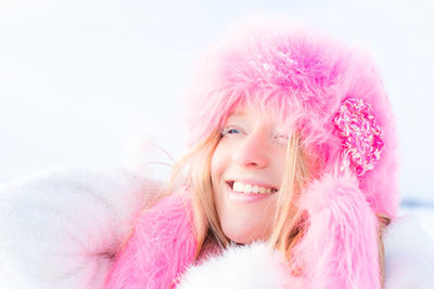 Portrait of beautiful young woman against pink sky