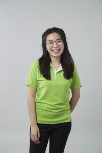 Portrait of smiling young woman against white background