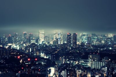 Illuminated cityscape against sky at night