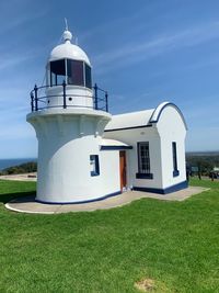 Lighthouse by sea against sky