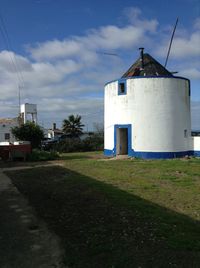 Built structure on field against cloudy sky