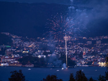 Firework display over illuminated buildings in city at night