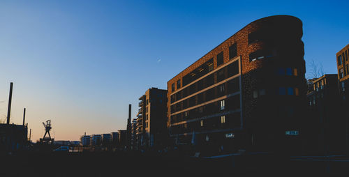 Low angle view of buildings against clear blue sky