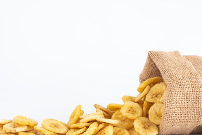 Close-up of fresh bread in plate against white background