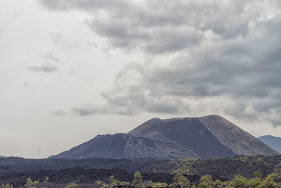 Scenic view of mountains against cloudy sky