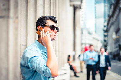 Young man using mobile phone in city