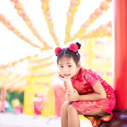 Portrait of smiling girl sitting outdoors