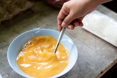 High angle view of person preparing food in bowl on table