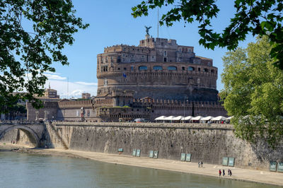 Arch bridge in city against sky