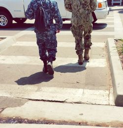 Low section of men standing on road