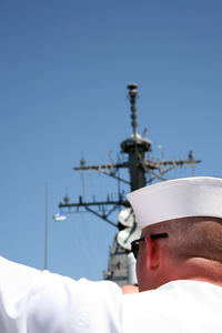 Close-up of man using smart phone against clear sky