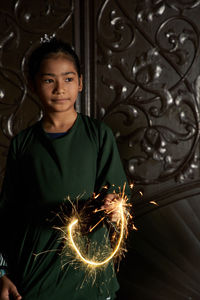 Portrait of malay girl holding sparkler during ramadan festival 