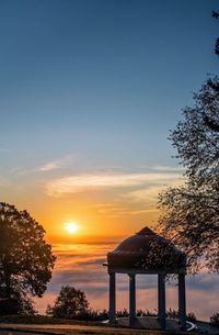 Gazebo on mountain against sky during sunset