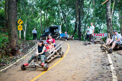 Group of people sitting on road in forest