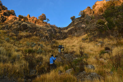 Rear view of people climbing on mountain