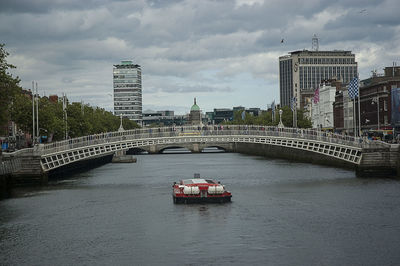 Bridge over river in city against sky