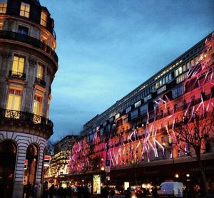 Low angle view of illuminated buildings against sky at dusk