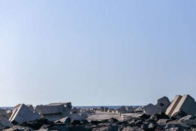 Stack of rocks by building against clear sky