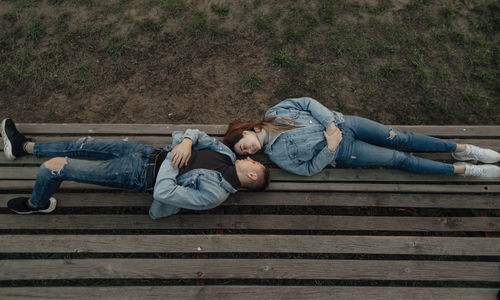 Happy young loving young couple relaxing on the bench in park