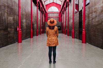 Full length rear view of woman walking on corridor of building