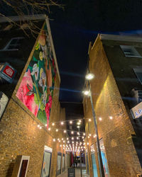 Low angle view of illuminated buildings against sky at night