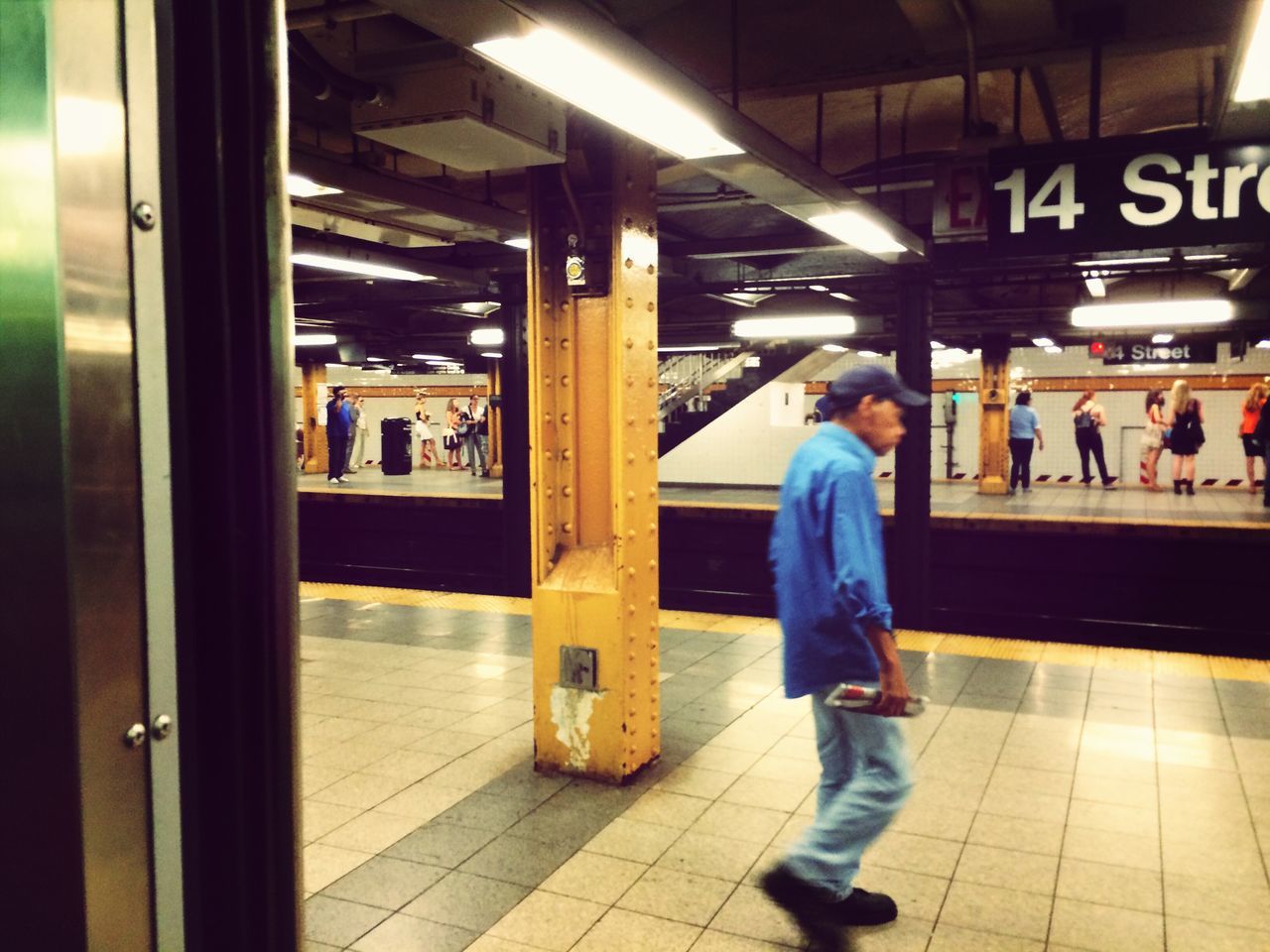 public transportation, indoors, railroad station, railroad station platform, lifestyles, transportation, full length, passenger, illuminated, subway station, standing, rail transportation, casual clothing, travel, train - vehicle, men, leisure activity, railroad track