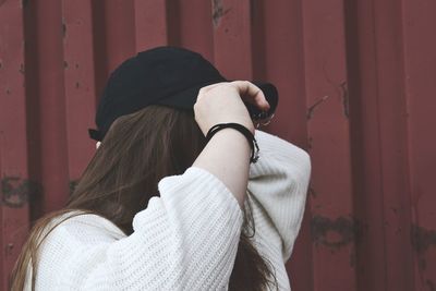 Rear view of woman standing against wall