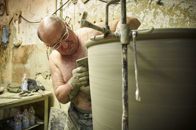 Potter in workshop working on large terracotta vase