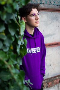 Portrait of teenage boy standing against wall