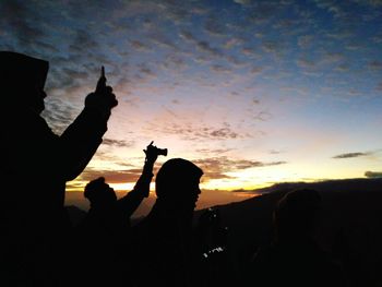 Silhouette people against sky during sunset