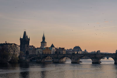 Scenic view of charles bridge over river vltava in prague at sunset 