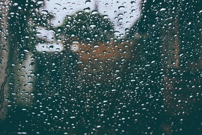 Close-up of waterdrops on glass against blurred background