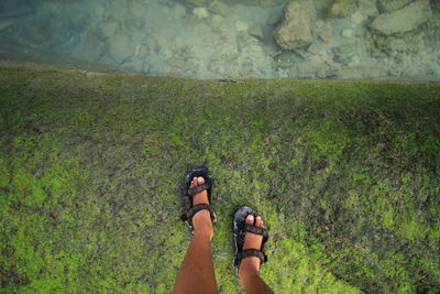 Low section of man standing in stone by water