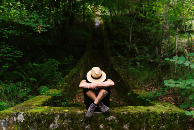 Full length of man sitting in forest