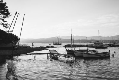 Boats moored in harbor against sky