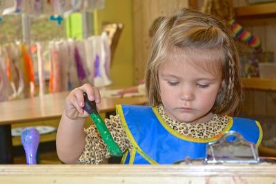 Close-up of girl holding sunglasses on table