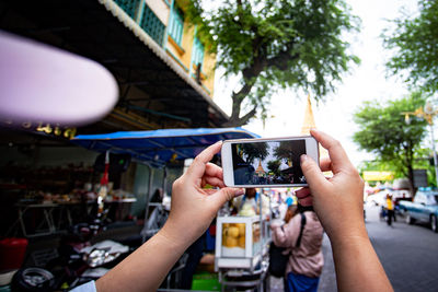 Midsection of woman photographing with mobile phone