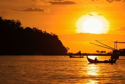 Silhouette boat in sea against sky during sunset