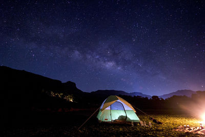 Scenic view of illuminated mountains against sky at night