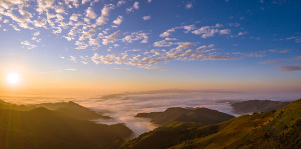 Scenic view of mountains and mist in valley during sunrise blue sky backgrounds 
