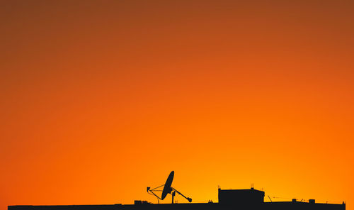 Low angle view of buildings against orange sky